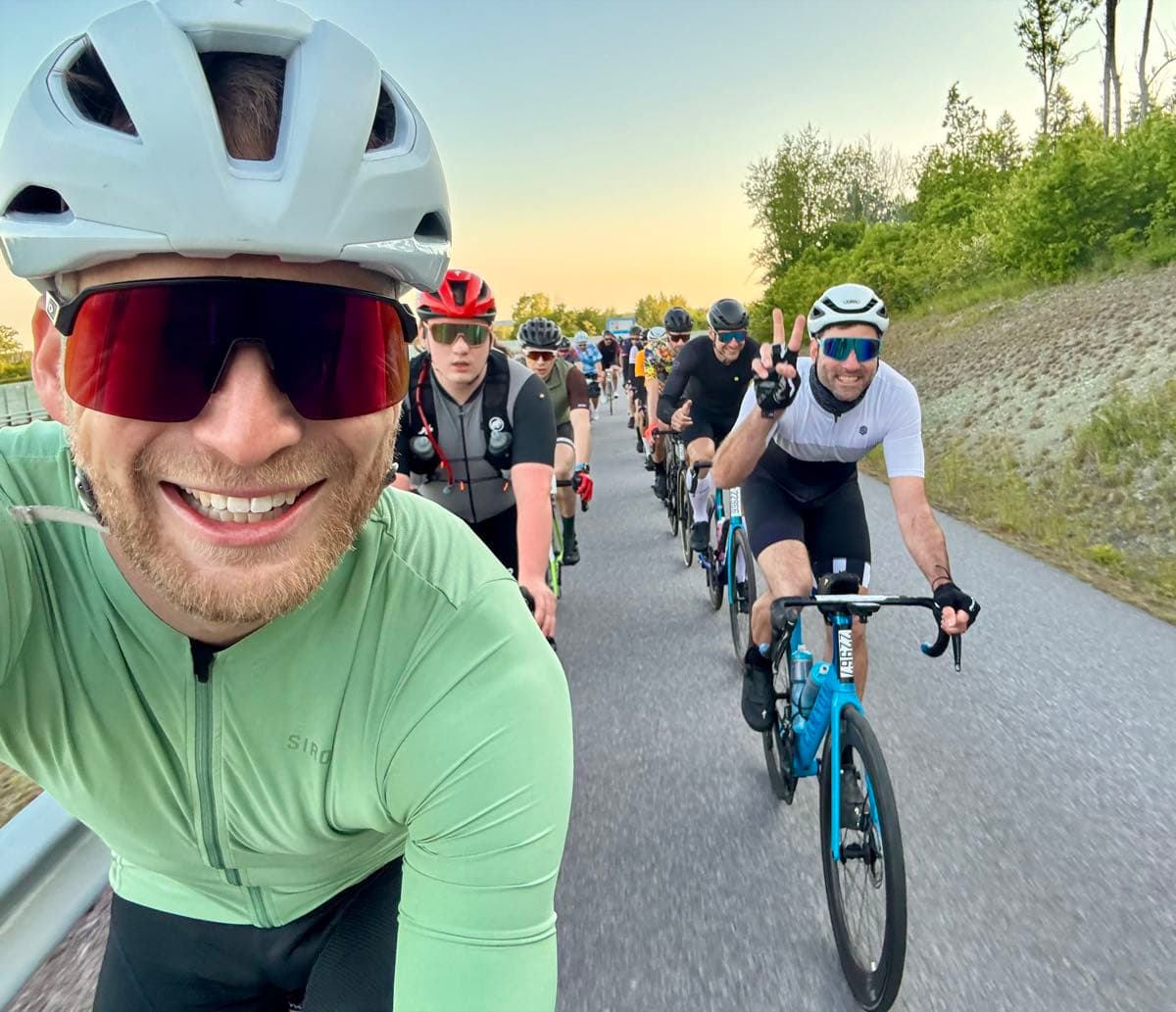 Golden-hour group road ride, a paceline stretching into the distance