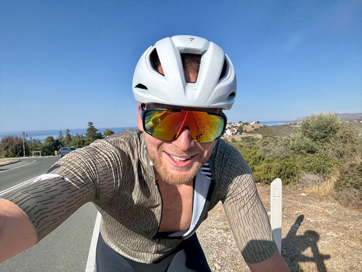 Road cycling along a sunny coastline, the sea behind