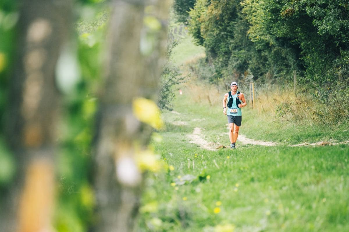 Running a green singletrack trail in the distance