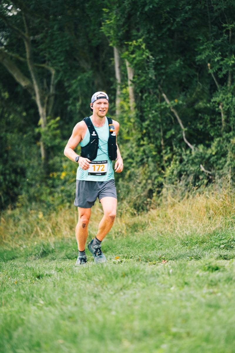 Trail running toward the camera, hydration vest on