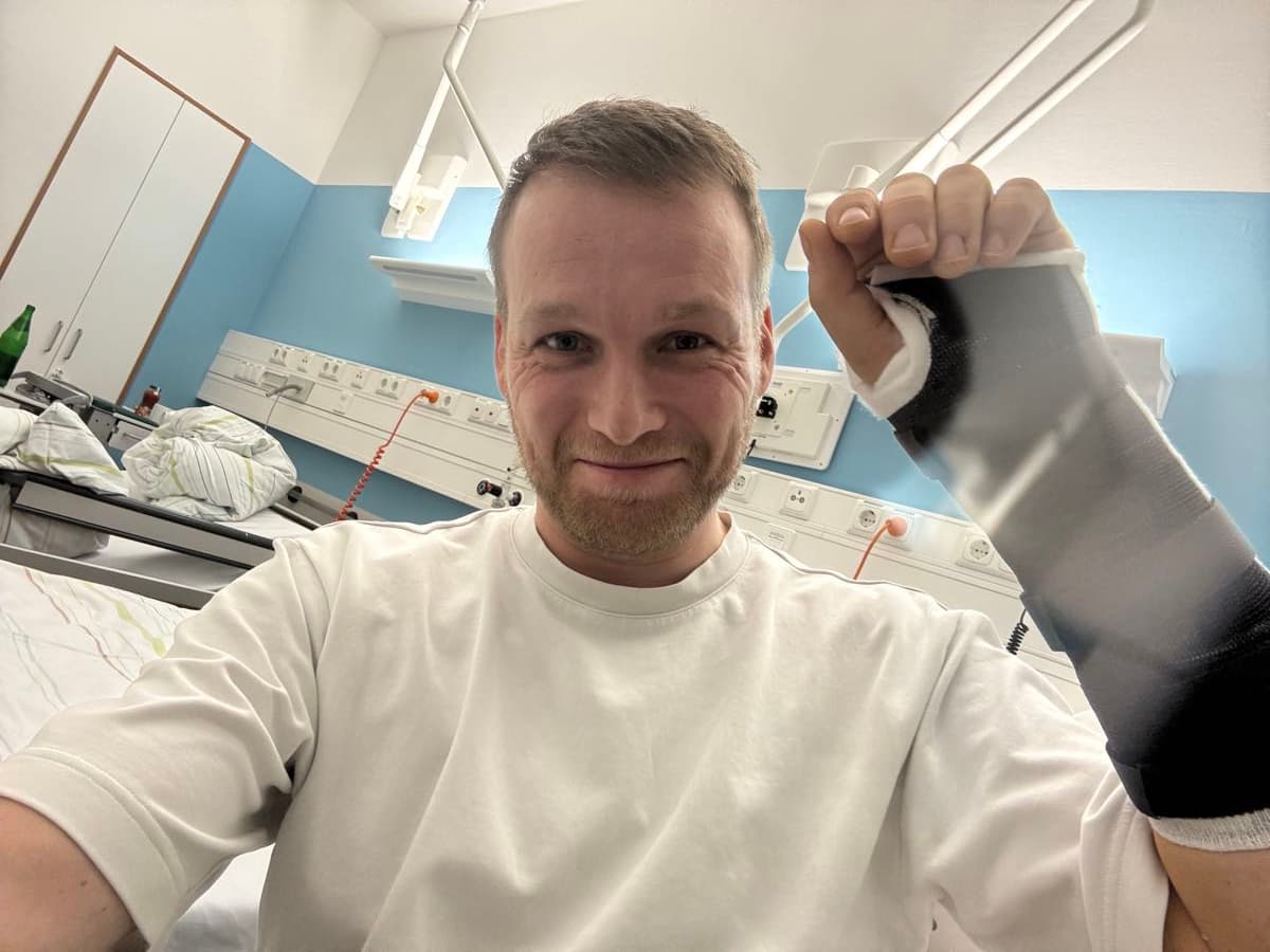 In hospital with a broken wrist in a cast, giving a wry thumbs up