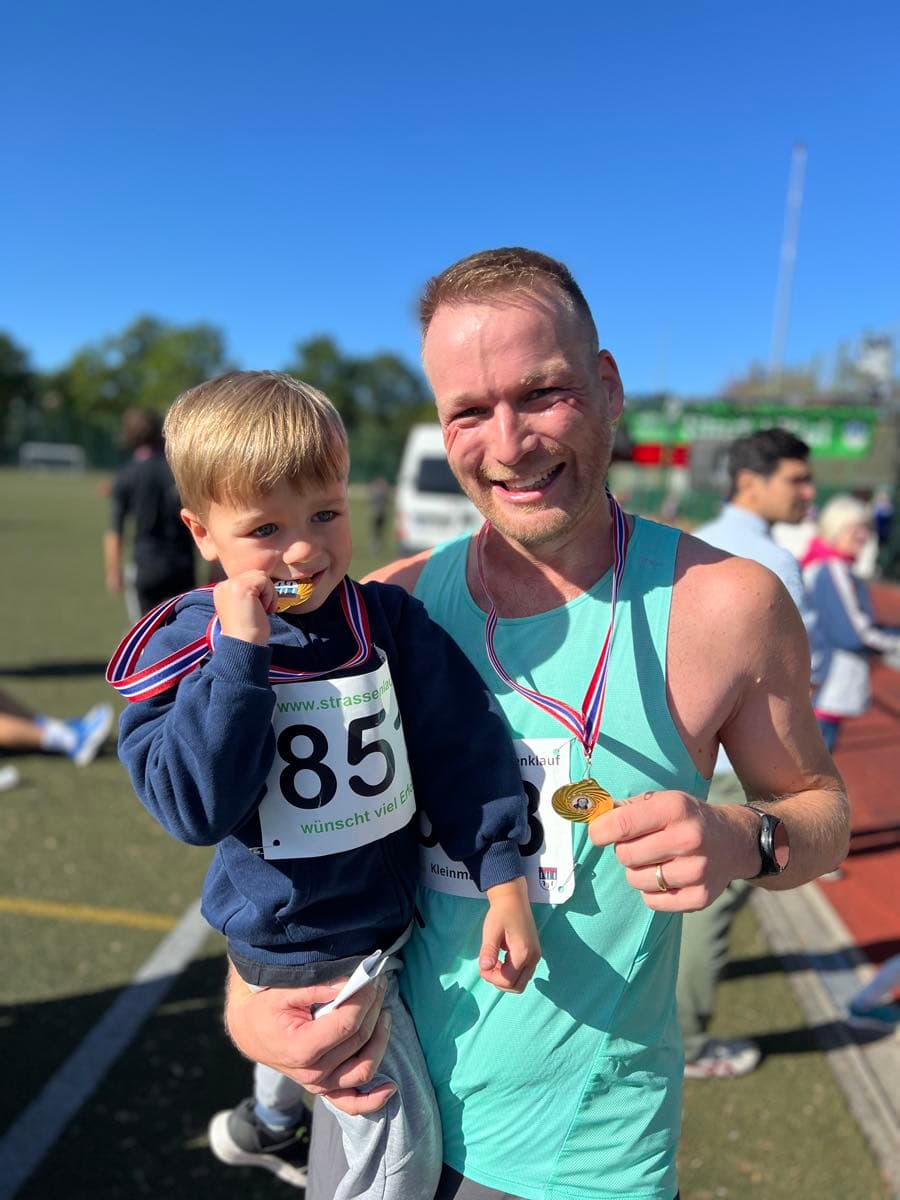 Holding my child, both wearing medals at the track